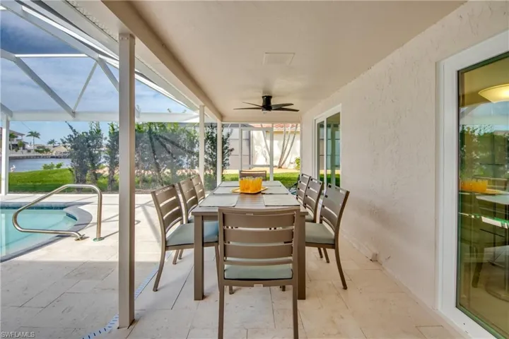 Sunroom / solarium featuring a water view, outdoor dining space, and a ceiling fan