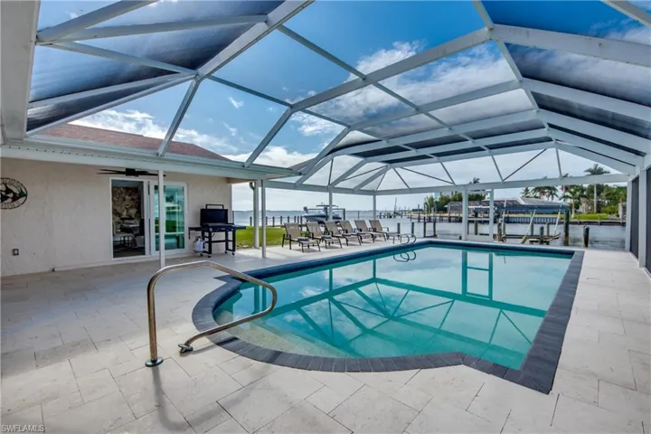Outdoor pool featuring a patio, ceiling fan, and a lanai