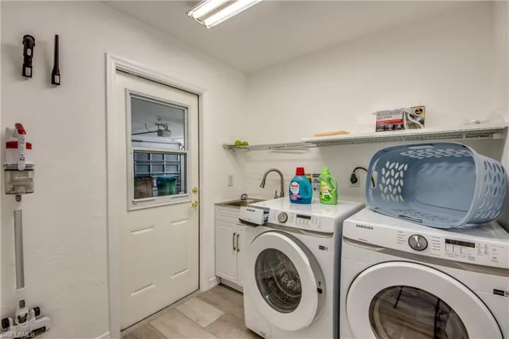 Laundry area with independent washer and dryer, cabinet space, and light wood finished floors