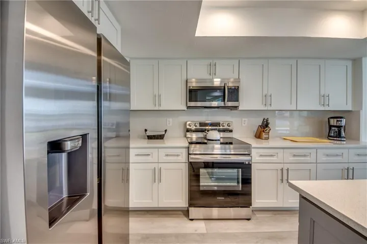 Kitchen with appliances with stainless steel finishes, white cabinetry, and light wood-style floors