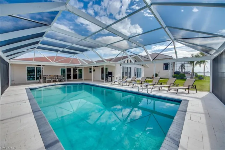 Outdoor pool featuring ceiling fan, a patio, a lanai, and outdoor dining area