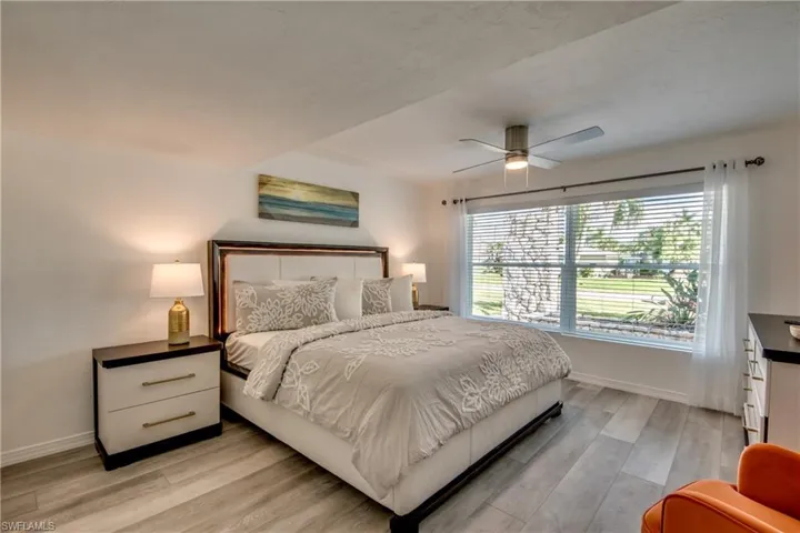 Bedroom with baseboards, light wood finished floors, and a ceiling fan