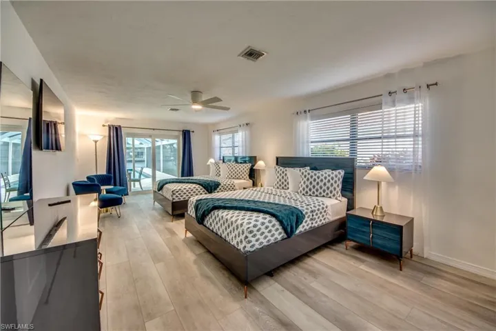 Bedroom with light wood finished floors, baseboards, and a ceiling fan