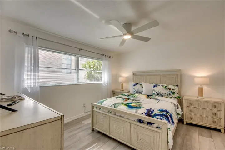 Bedroom featuring light wood-style floors, a ceiling fan, and baseboards