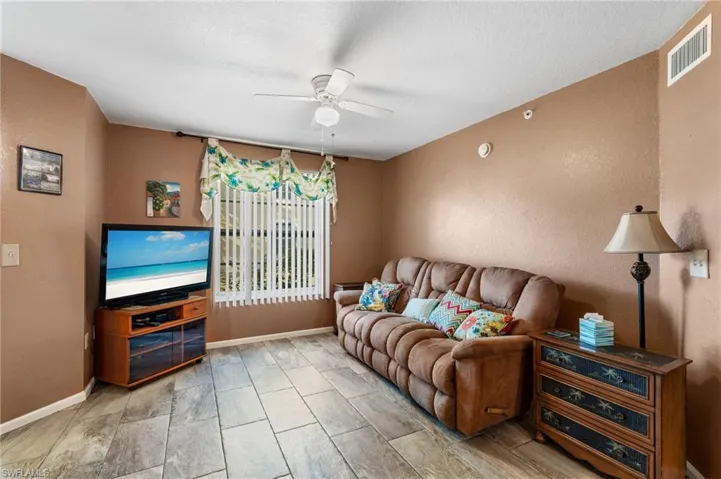 Living room with a textured ceiling and ceiling fan