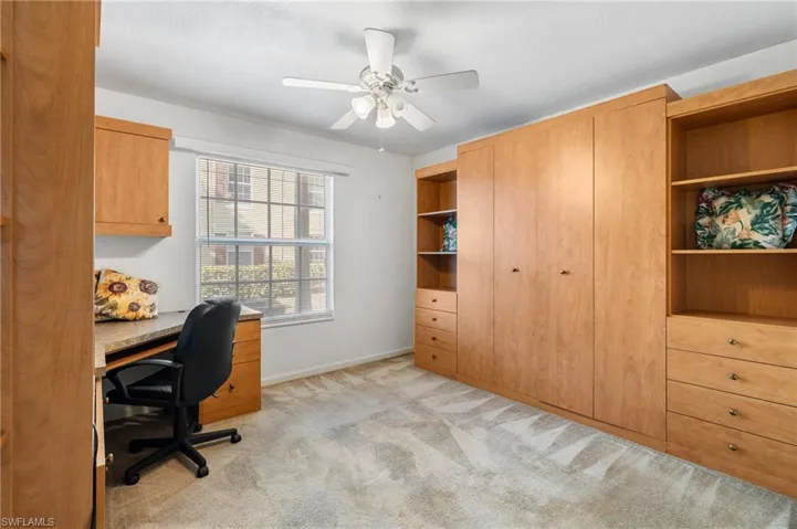 Office area with light carpet and ceiling fan