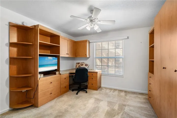 Carpeted home office with ceiling fan and a textured ceiling