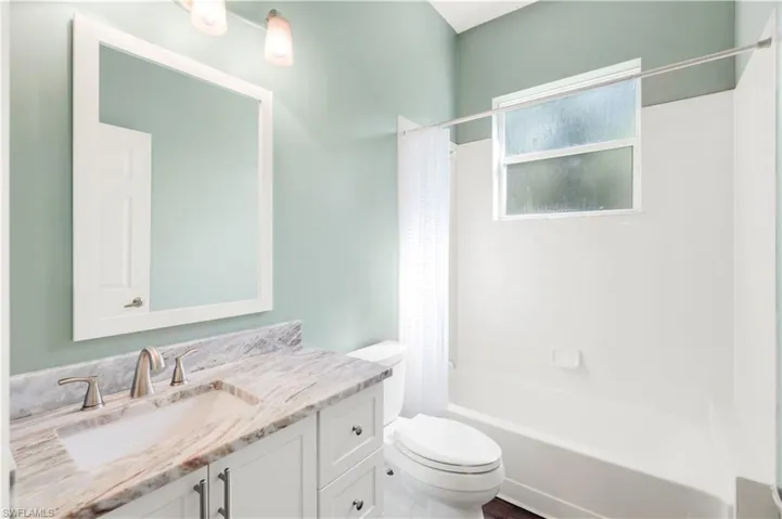 GUEST BATH HAS TUB SHOWER COMBO AND STONE COUNTER