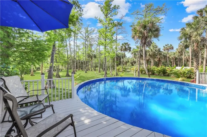 CUSTOM WRAP AROUND POOL DECK RECENTLY PAINTED, READY WITH CHAIRS AND UMBRELLAS