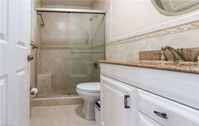 Full bathroom with vanity, a stall shower, tile walls, and tile patterned flooring