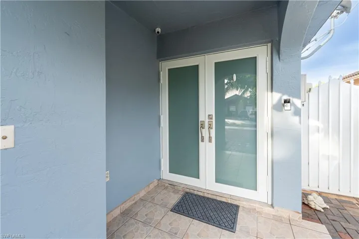 View of exterior entry featuring french doors and stucco siding