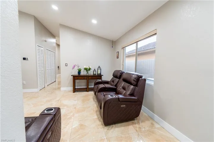 Living area featuring vaulted ceiling and recessed lighting
