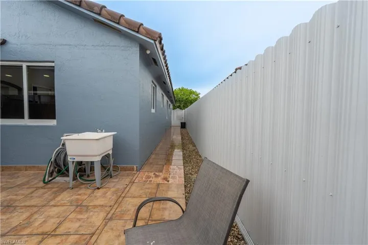 Fenced backyard with a patio area and a sink