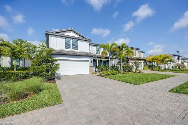 View of front facade featuring decorative driveway and a garage