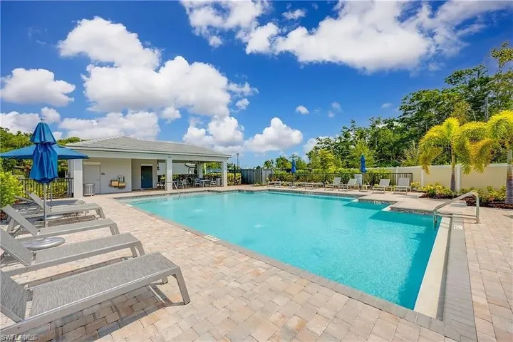Community pool featuring a patio and fence