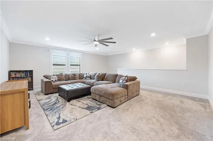 Living area with a ceiling fan, crown molding, light carpet, recessed lighting, and baseboards
