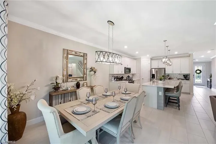 Dining space with a chandelier, ornamental molding, recessed lighting, and baseboards