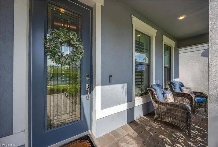 Entrance to property featuring stucco siding and a porch