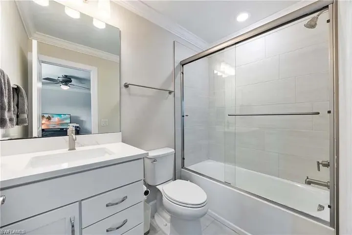 Full bathroom featuring ornamental molding, toilet, vanity, bath / shower combo with glass door, and recessed lighting
