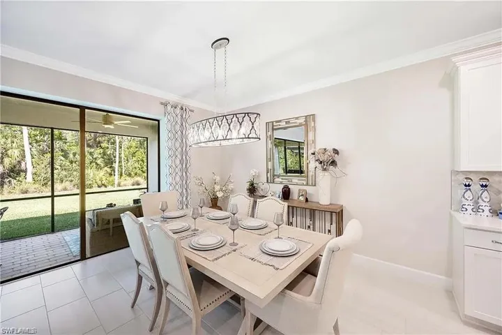 Dining space with crown molding, baseboards, and light tile patterned floors