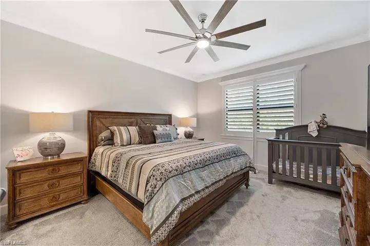 Bedroom with light carpet, crown molding, and ceiling fan