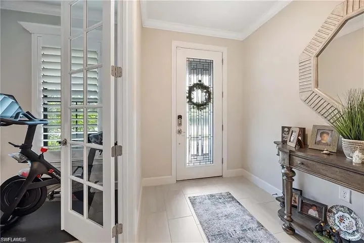 Tiled entrance foyer with healthy amount of natural light, ornamental molding, and baseboards