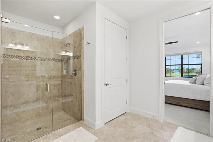 Full bathroom featuring ensuite bathroom, recessed lighting, and a shower stall