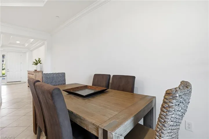 Dining area featuring light tile patterned floors, ornamental molding, and recessed lighting