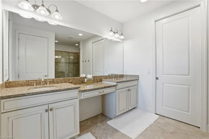 Full bathroom with a shower stall, double vanity, recessed lighting, and light tile patterned floors