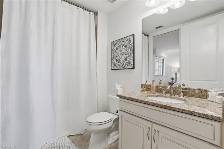 Bathroom featuring vanity, a shower with shower curtain, and light tile patterned floors