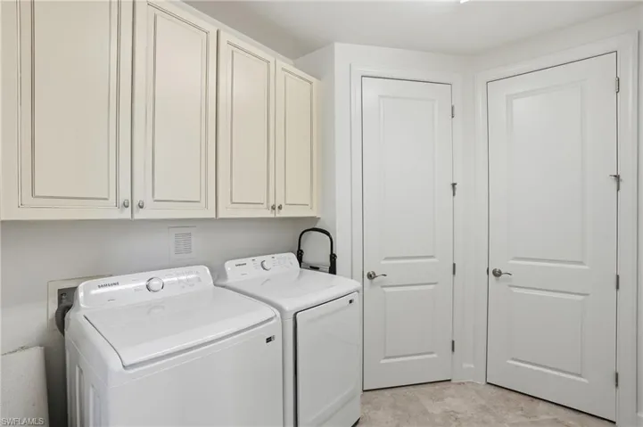 Washroom featuring cabinet space and washing machine and clothes dryer