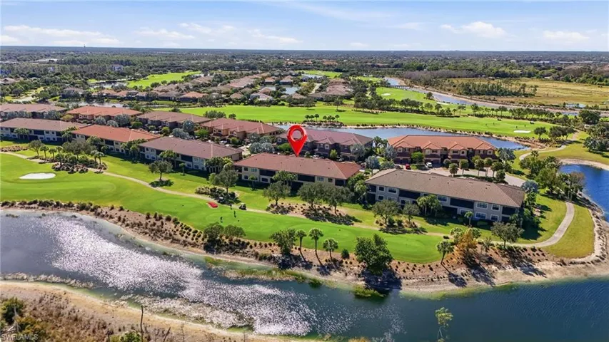 Aerial perspective of suburban area featuring a large body of water and a golf course