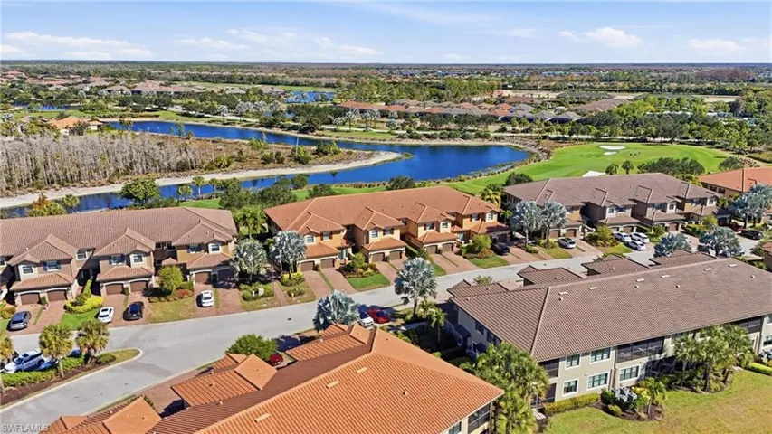 Aerial view of residential area featuring a nearby body of water and a golf club