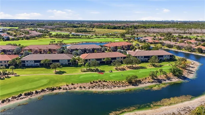 Aerial view of residential area with a nearby body of water and a golf club