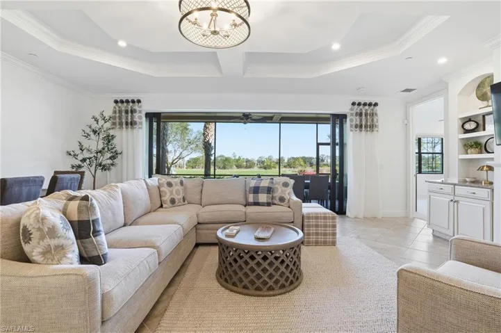 Living area featuring plenty of natural light, a chandelier, light tile patterned floors, crown molding, and recessed lighting