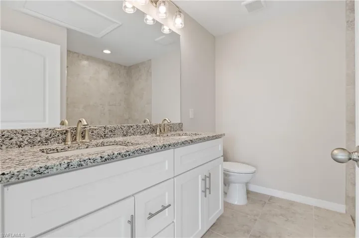 Bathroom featuring double vanity and light tile patterned floors