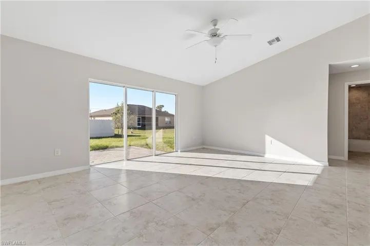 Unfurnished room with light tile patterned flooring, a ceiling fan, and lofted ceiling