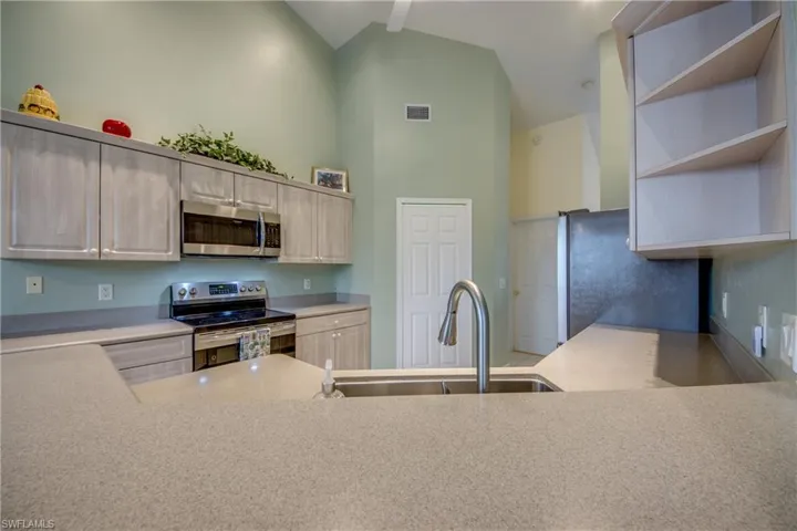 Corian Countertops a Large Farmers sink, newer Stainless steel appliances adorn the kitchen.  Behind the white door is a large pantry.