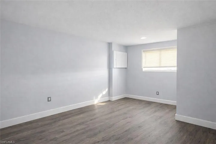 Unfurnished room with dark wood-type flooring and a textured ceiling