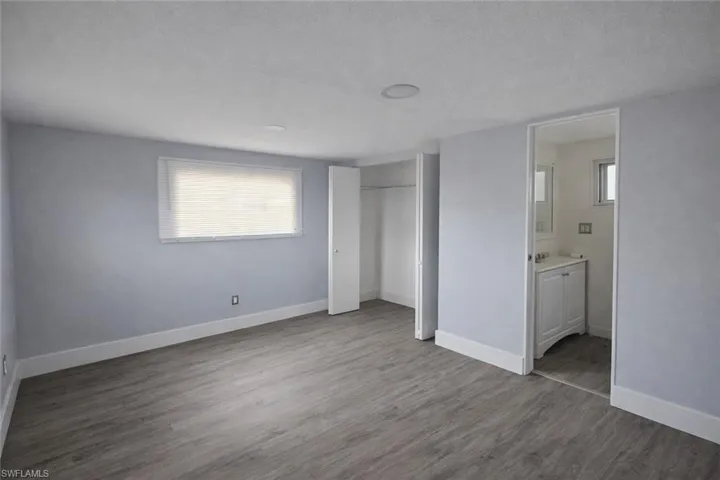 Unfurnished bedroom with wood finished floors, a textured ceiling, multiple windows, and a closet