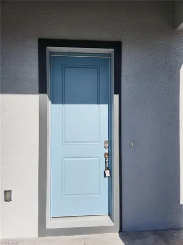 Doorway to property with stucco siding