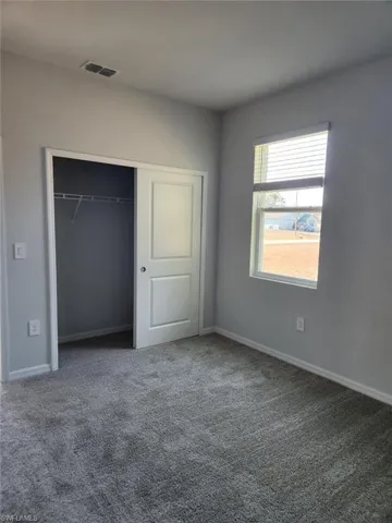 Unfurnished bedroom featuring carpet and a closet
