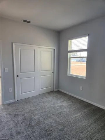 Unfurnished bedroom with a closet and carpet floors