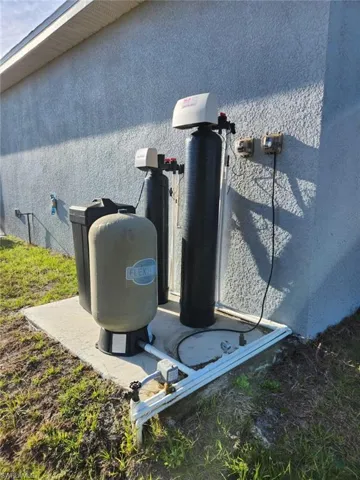 Exterior view of stucco siding and a water softener