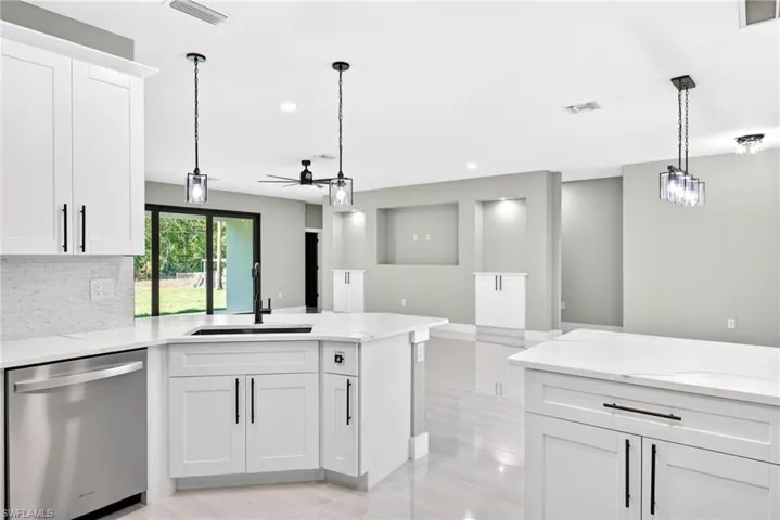 Kitchen with white cabinets, pendant lighting, stainless steel dishwasher, a peninsula, and recessed lighting