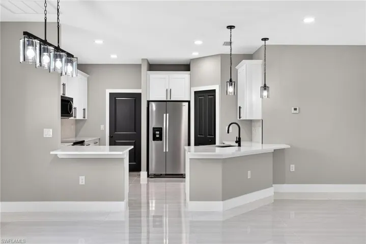Kitchen featuring a peninsula, stainless steel appliances, decorative backsplash, and recessed lighting