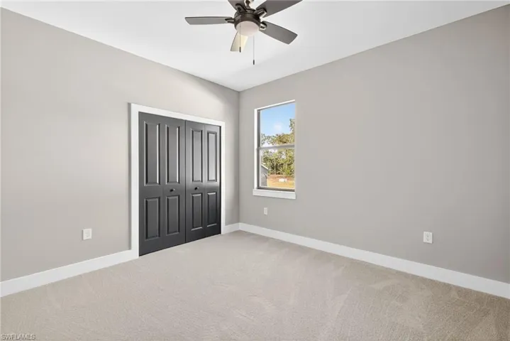 Unfurnished bedroom with a closet, carpet flooring, and a ceiling fan