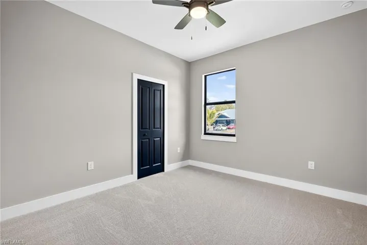 Unfurnished bedroom featuring carpet flooring, ceiling fan, and a closet