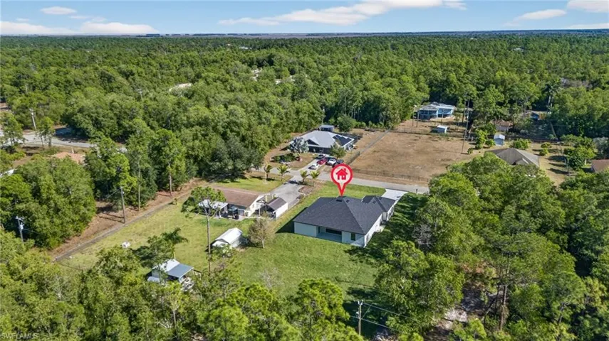 Aerial overview of property's location with a heavily wooded area
