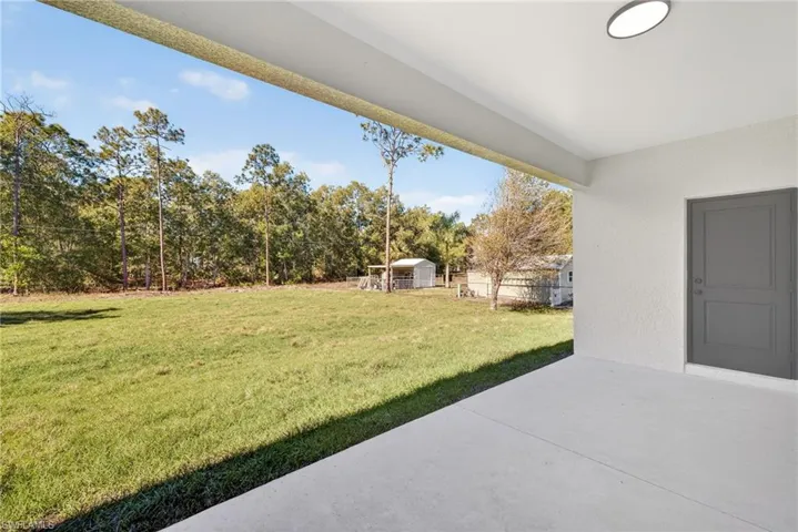 View of yard featuring a patio and a storage shed